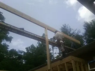 Carpenter setting a ridge beam over a new addition frame — Ice Dam Removal by Roofing Brothers in Republic